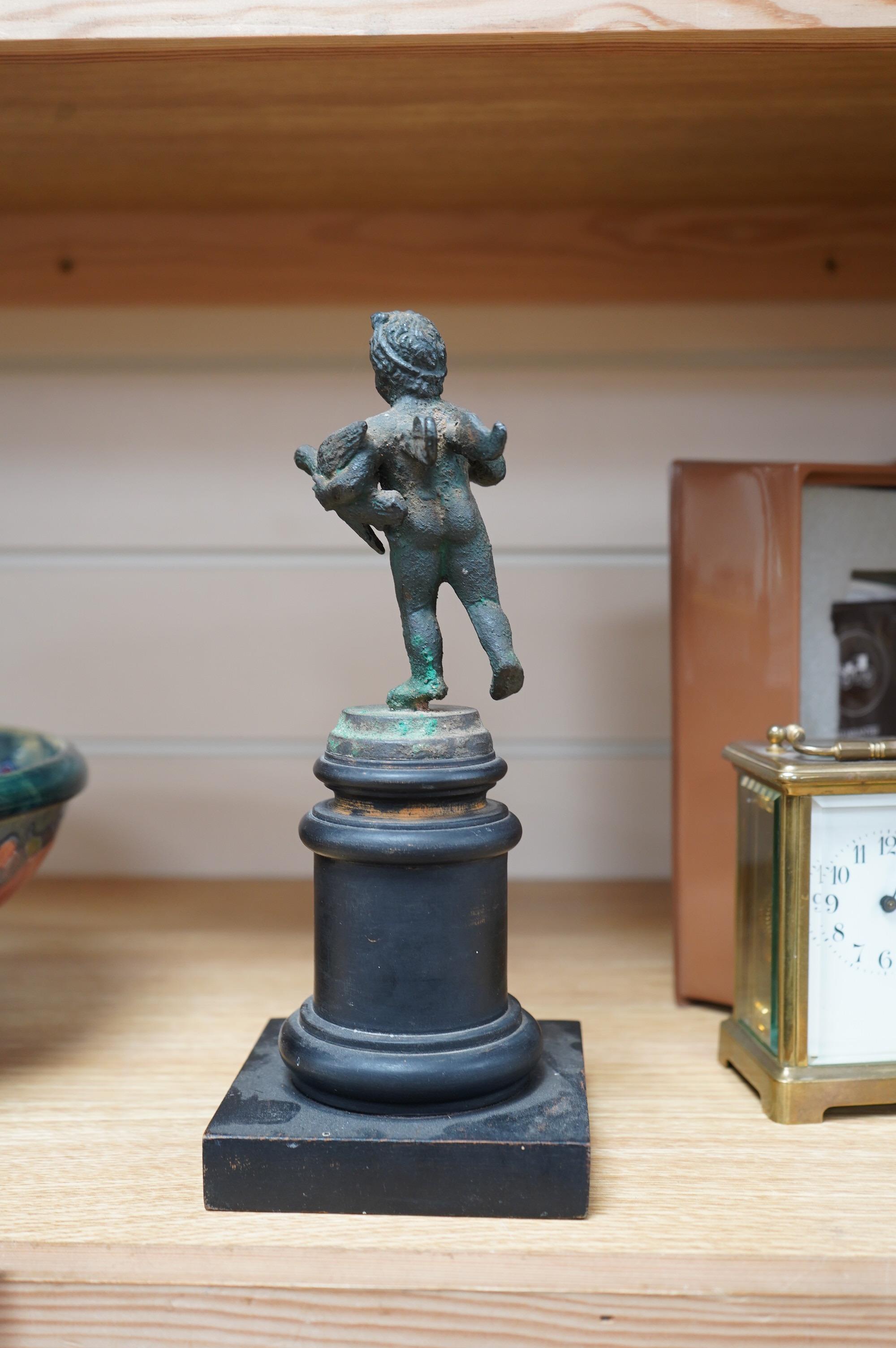 A bronze model of a putto, possibly Roman, holding a duck, on a circular plinth, 24.5cm. Condition - fair to good.